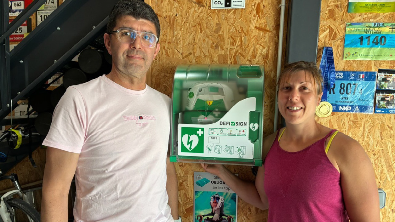 Medisol schenkt AED aan sportschool. Eigenaren bij geschonken AED in wandkast.